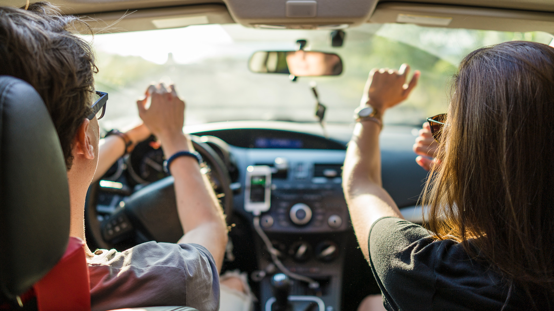 Friends dancing while on a road trip during beautiful summer day - stock photo