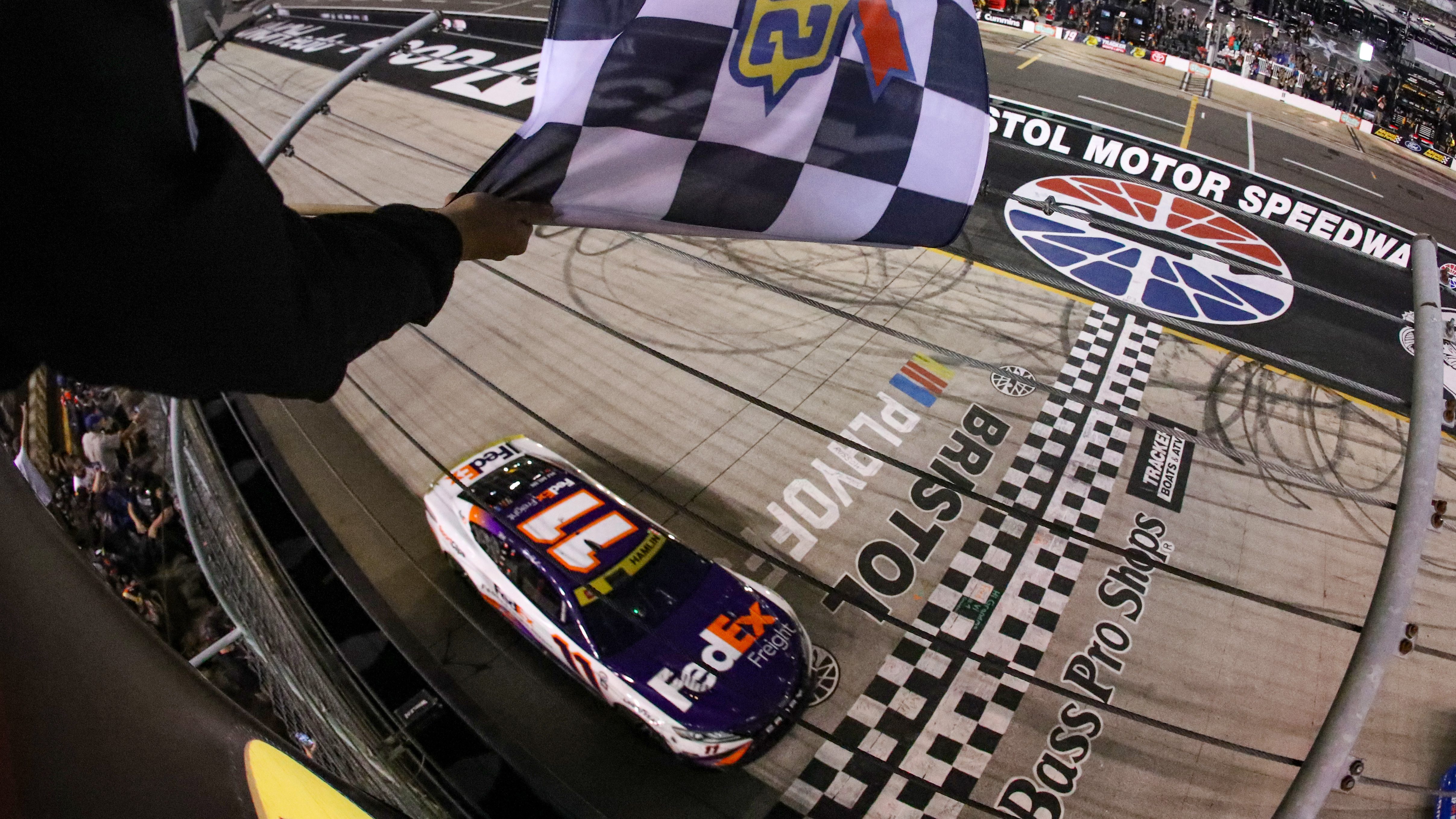 BRISTOL, TENNESSEE - SEPTEMBER 16: Denny Hamlin, driver of the #11 FedEx Freight Direct Toyota, takes the checkered flag to win the NASCAR Cup Series Bass Pro Shops Night Race at Bristol Motor Speedway on September 16, 2023 in Bristol, Tennessee. (Photo by Meg Oliphant/Getty Images)