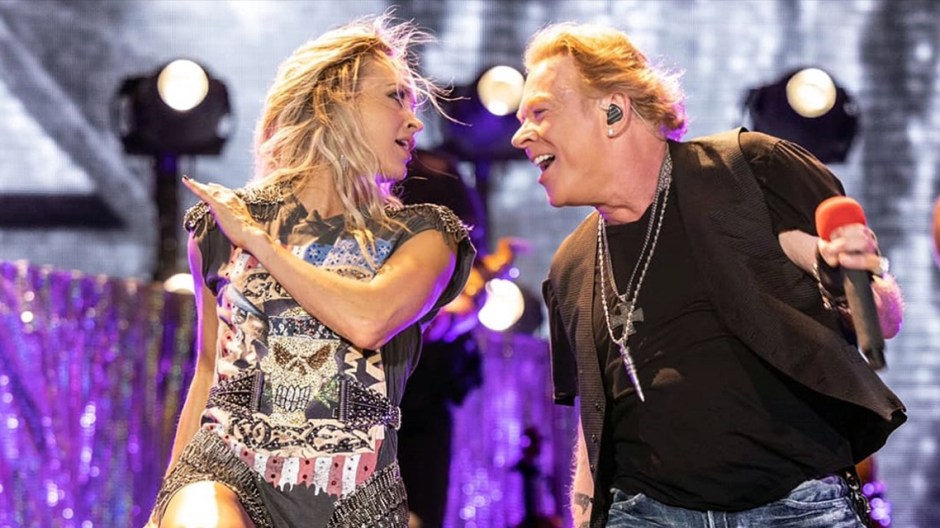 Image of Carrie Underwood and Axl Rose performing hard rock together on stage.